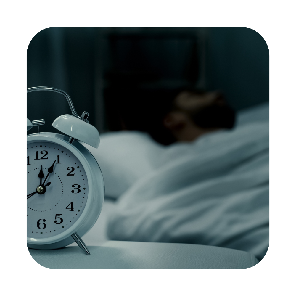 Man in bed sleeping next to alarm clock